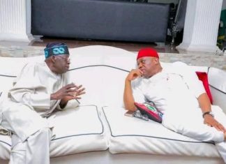 Nobody can defeat Tinubu in a free, fair election – Orji Kalu Two men wearing traditional outfits sit on a white couch, engaged in conversation in a stylish living room setting.