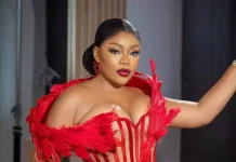Ashmusy opens up on decision to freeze her eggs Woman in a red feathered corset posing with hand on hip during a fashion photoshoot.