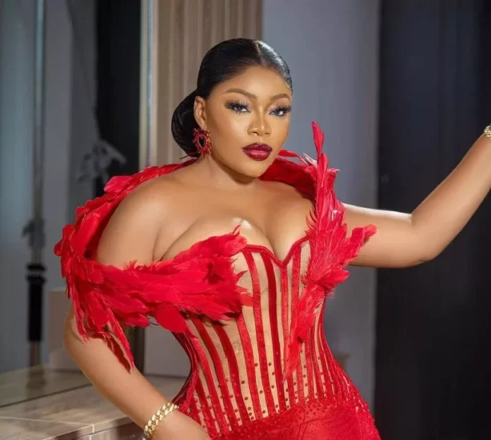 Woman in a red feathered corset posing with hand on hip during a fashion photoshoot.