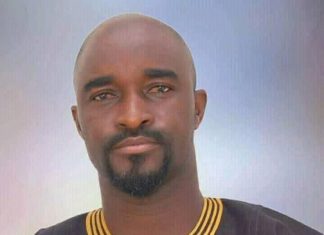 Actor Don Richard not dead amid rumours Portrait of a man with a goatee wearing a black traditional African outfit with gold embroidery, facing the camera.