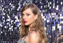 Taylor Swift moves to trademark voice, image after AI concerns Taylor Swift in a shimmering silver sequin gown posing against a reflective sequin backdrop at a glamorous event.