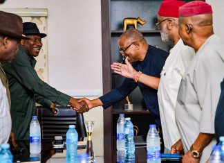 Jonathan has not endorsed my 2027 presidential ambition – Peter Obi Two men in business attire shake hands across a conference table as others look on in a formal meeting setting.
