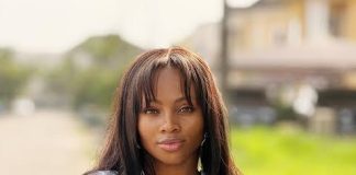 ‘Why I won’t advise friends to go for BBNaija,’ – Tega Dominic Woman with shoulder-length hair standing outdoors with arms crossed, wearing a white shirt and a watch, looking at the camera.
