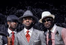 ‘Don’t bring shame on Ndi Igbo,’ J Martins weighs in on Peter, Paul Okoye feud Three men in stylish suits posing for a portrait, wearing hats and sunglasses against a dark backdrop.
