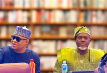 Why re-electing Tinubu is a task that must be done – Fani-Kayode, Omokri Two men in colorful traditional outfits sit at a table in a book-lined room; the left man wears blue with sunglasses and a patterned cap, the right wears green with a head wrap.
