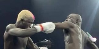 N1.3bn fight night: Carter Efe, Portable deliver big impact (Total Breakdown) Two shirtless male boxers sparring in a ring; the left boxer lands a punch to the opponent's head, both wearing white gloves with red trim.