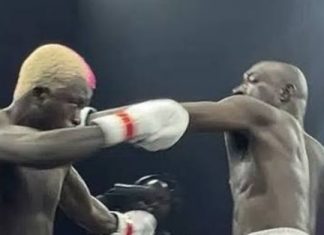 N1.3bn fight night: Carter Efe, Portable deliver big impact (Total Breakdown) Two shirtless male boxers sparring in a ring; the left boxer lands a punch to the opponent's head, both wearing white gloves with red trim.