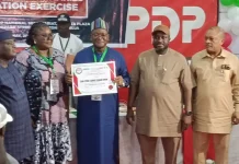 2027: Wike-backed PDP picks Sandy Onor as presidential candidate Six people stand on a stage during an awards event; a man in blue traditional attire holds a framed certificate as others pose nearby.