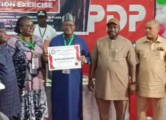 2027: Wike-backed PDP picks Sandy Onor as presidential candidate Six people stand on a stage during an awards event; a man in blue traditional attire holds a framed certificate as others pose nearby.
