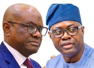 Wike dismisses PDP-APM alliance, says Makinde’s presidential ambition ‘dead on arrival’ Two men in conversation, one in a blue suit and red tie, the other in a blue traditional cap and attire, against a white background.