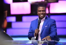 Pastor Bolaji Idowu speaks on infidelity in marriage, forgiveness Smiling man in a blue suit speaks into a microphone at a podium on a lit purple stage.