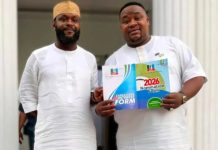 Seyi Tinubu encourages Cubana Chief Priest after APC ticket loss Two men in white traditional attire stand together; one holds a colorful 2026 nomination form booklet.