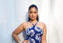 Nollywood producers prioritise beauty over talent- Shine Rosman Portrait of a woman in a blue halter dress with white flowers, standing against light curtains and posing with hands on hips.