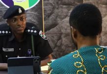 Arrested TikToker: I staged fake bandit videos to become famous like Peller Female police officer in uniform sits at a desk, speaking with a man in a teal patterned shirt; a tablet rests on the desk between them.