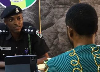 Arrested TikToker: I staged fake bandit videos to become famous like Peller Female police officer in uniform sits at a desk, speaking with a man in a teal patterned shirt; a tablet rests on the desk between them.