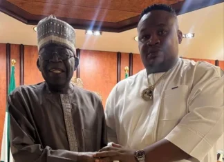 2027: ‘Tinubu doesn’t trust me as an Igbo man’ – Cubana Chief Priest Two men in traditional Nigerian attire shake hands in a formal room, with flags in the background. One wears a dark brown kaftan and cap, the other a white tunic with a gold chain.