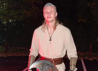 Haaland to make acting debut as Viking in animated film Person in medieval cosplay stands outdoors at night, wearing a beige tunic, leather bracers, belt, and holding a round shield with a cross emblem