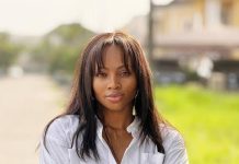 I will not let this slide – Tega Dominic speaks on alleged affair with Frank Edoho Portrait of a woman with long dark hair standing outdoors with arms crossed, wearing a white shirt and a gold watch, looking at the camera.